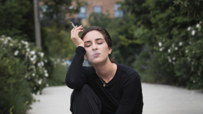 photo-of-a-woman-sitting-on-gray-floor-smoking-cigarette